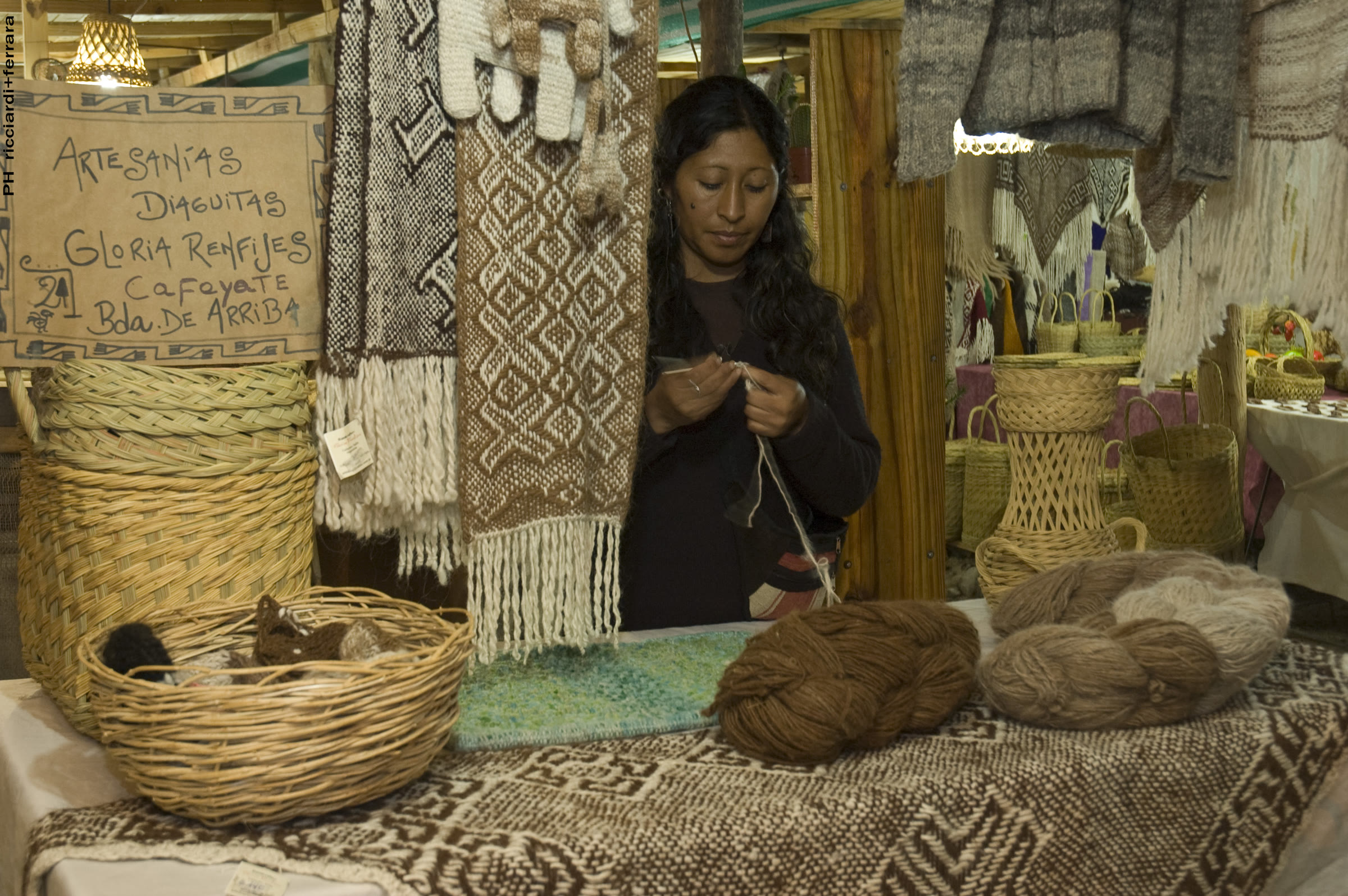 Ponchos y tejidos colgados en exposición